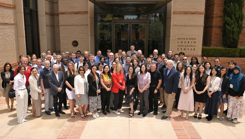 Group of scientists smile for the camera in front of a building