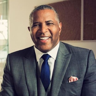 Robert F. Smith, smiling in a suit and blue tie