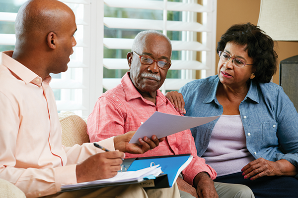 Financial Advisor Talking To Senior Couple At Home