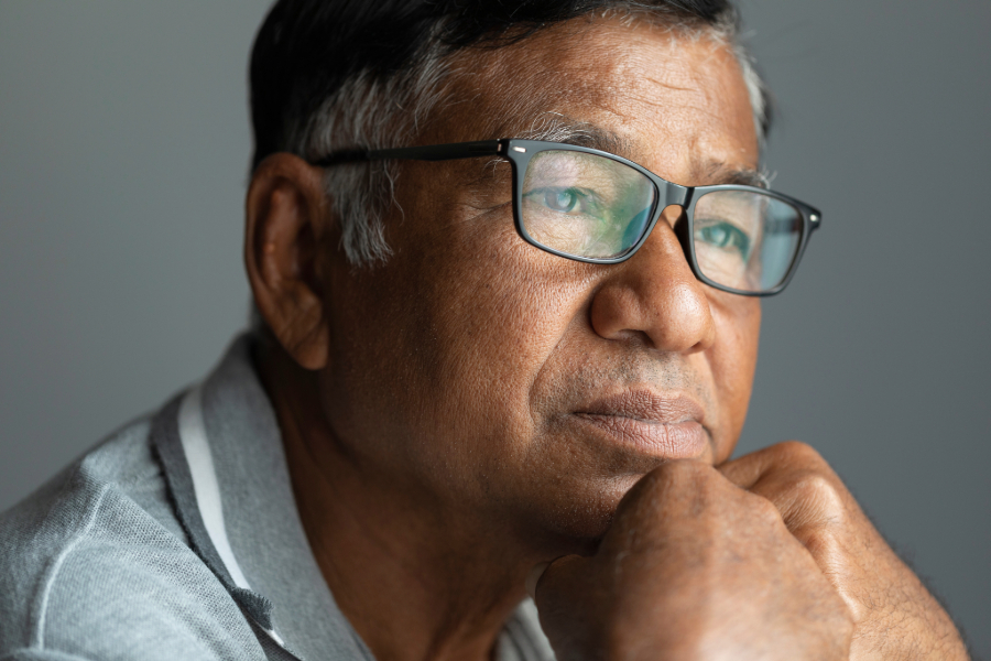 Man with glasses, chin resting on fist