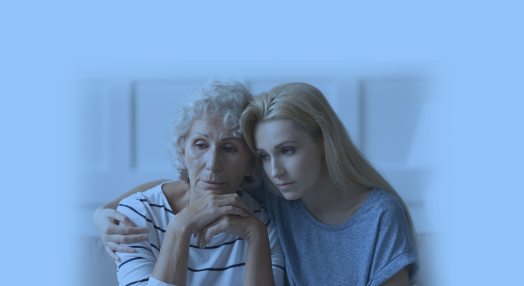 elderly woman and adult woman embracing